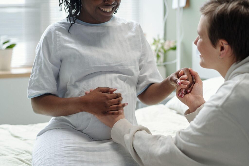 Supporting a pregnant woman while holding hands through personal mentorship | Unplanned Pregnancy Resources